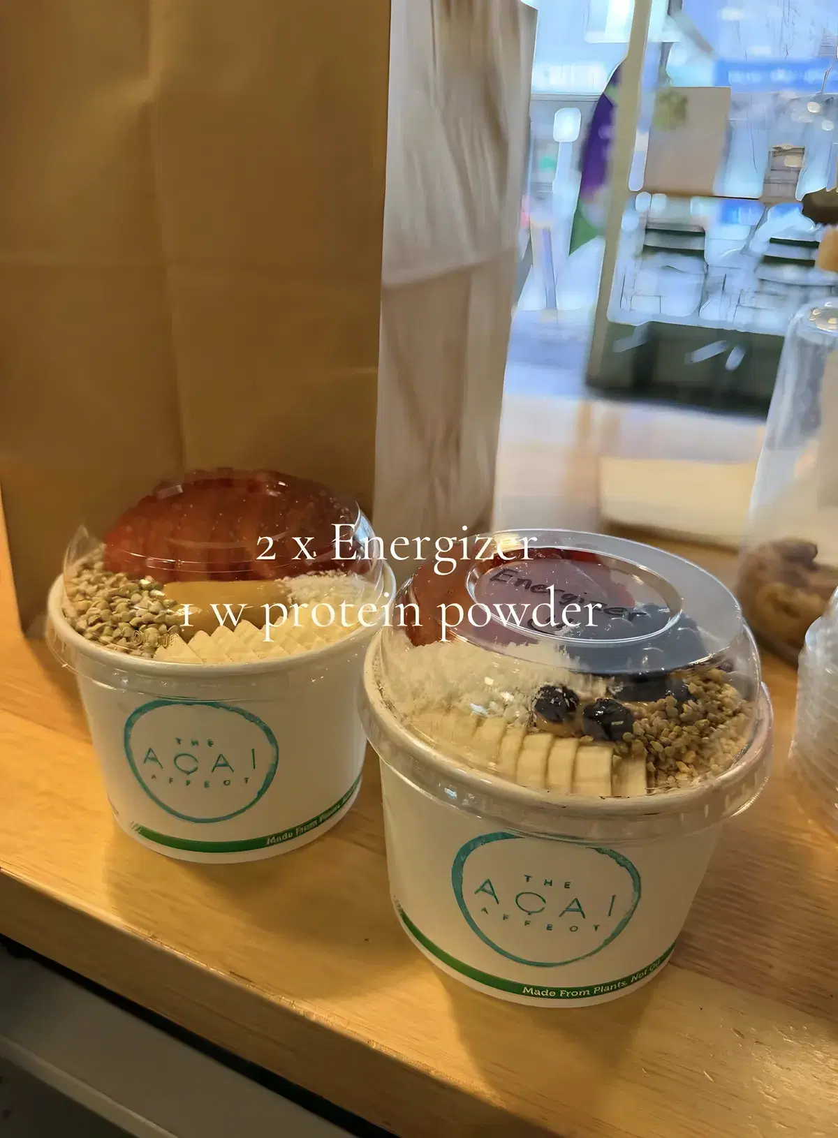 Two Energizer acai bowls in lidded takeaway cups, ready for pickup