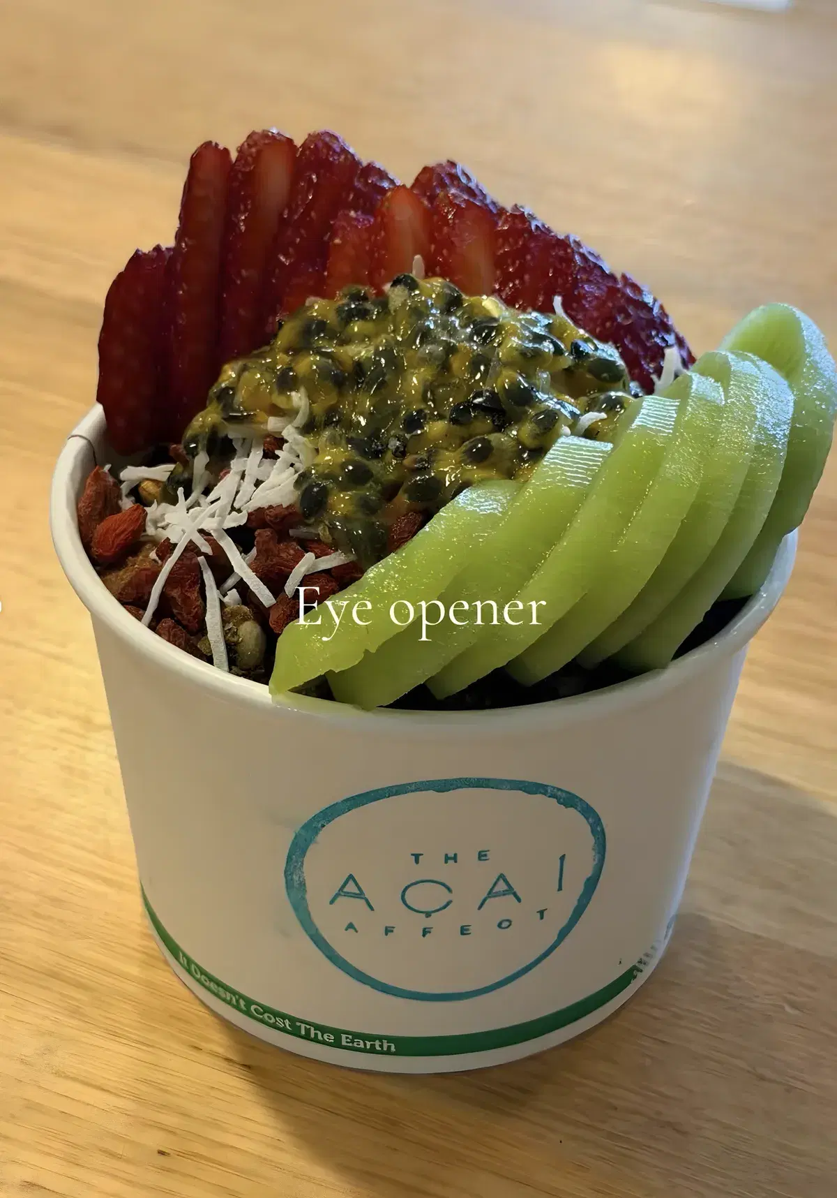 Eye Opener acai bowl in a takeaway cup with kiwi fruit, strawberries, passionfruit and coconut