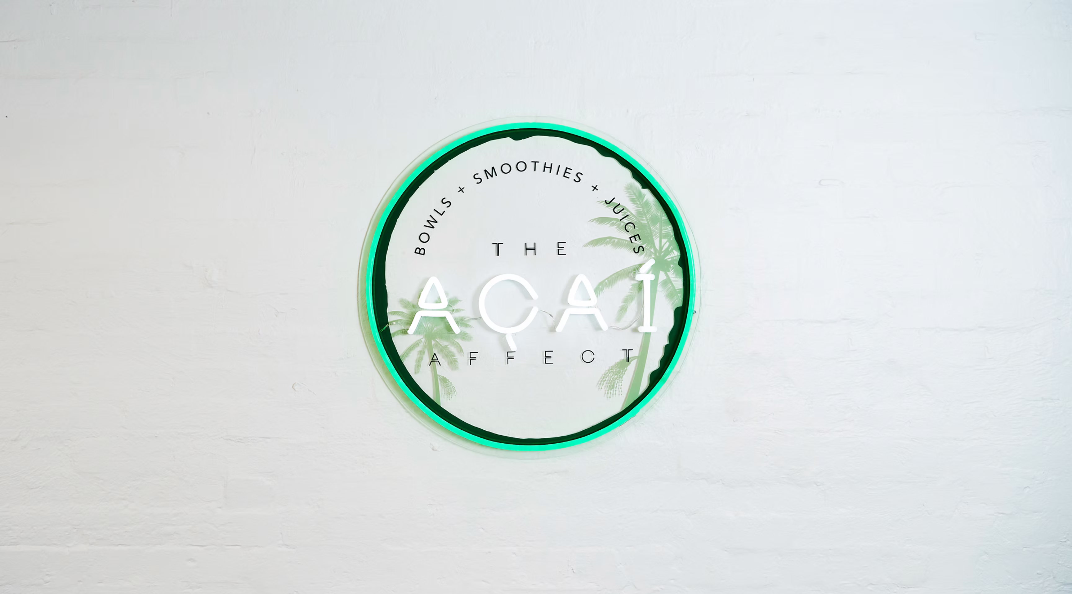 The Acai Affect sign on a white brick wall